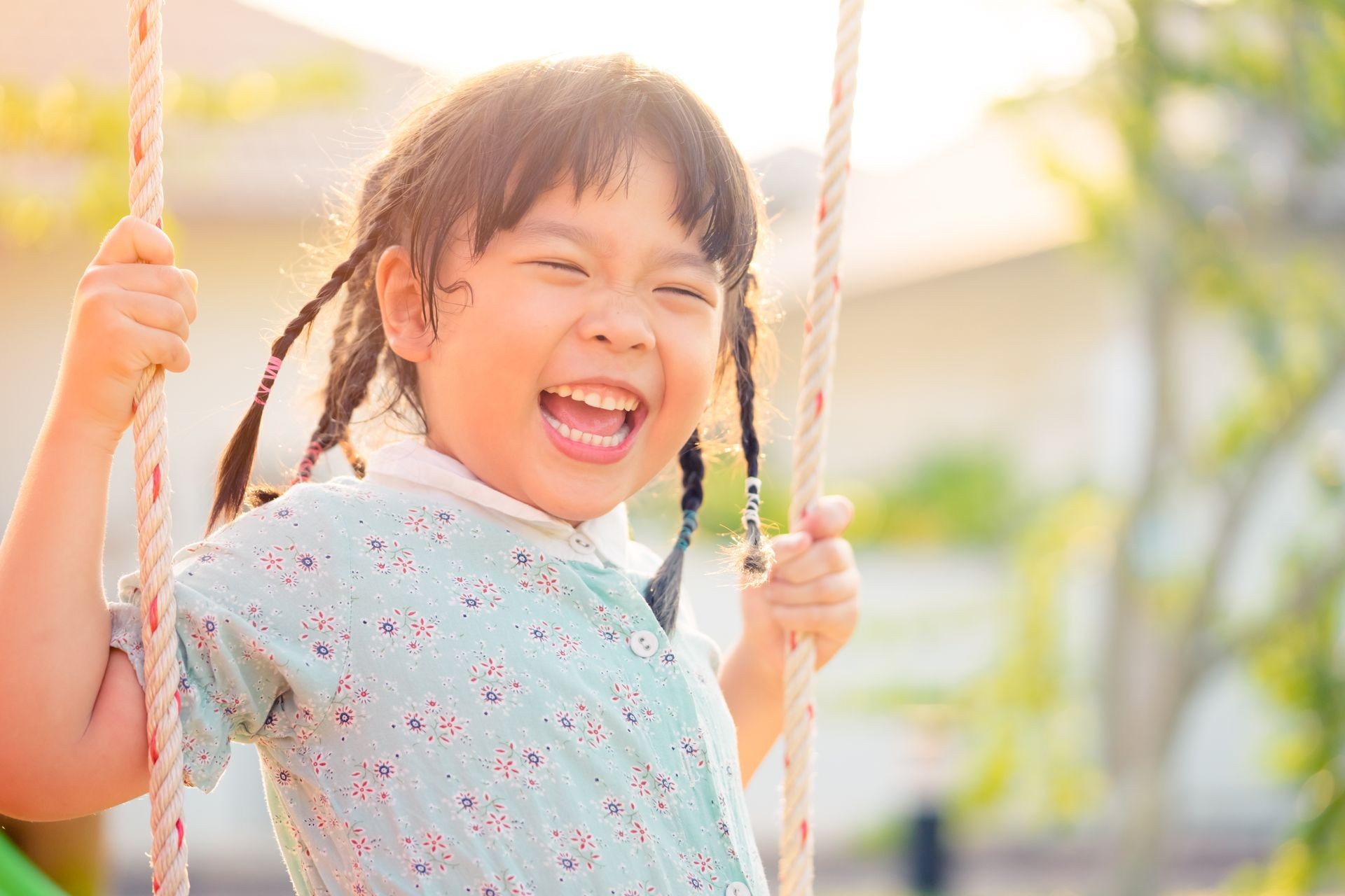 Asian child girl playing on playground in outdoor park.Happy Little asian girl playing swing with her mother.Happy moment and good emotion.